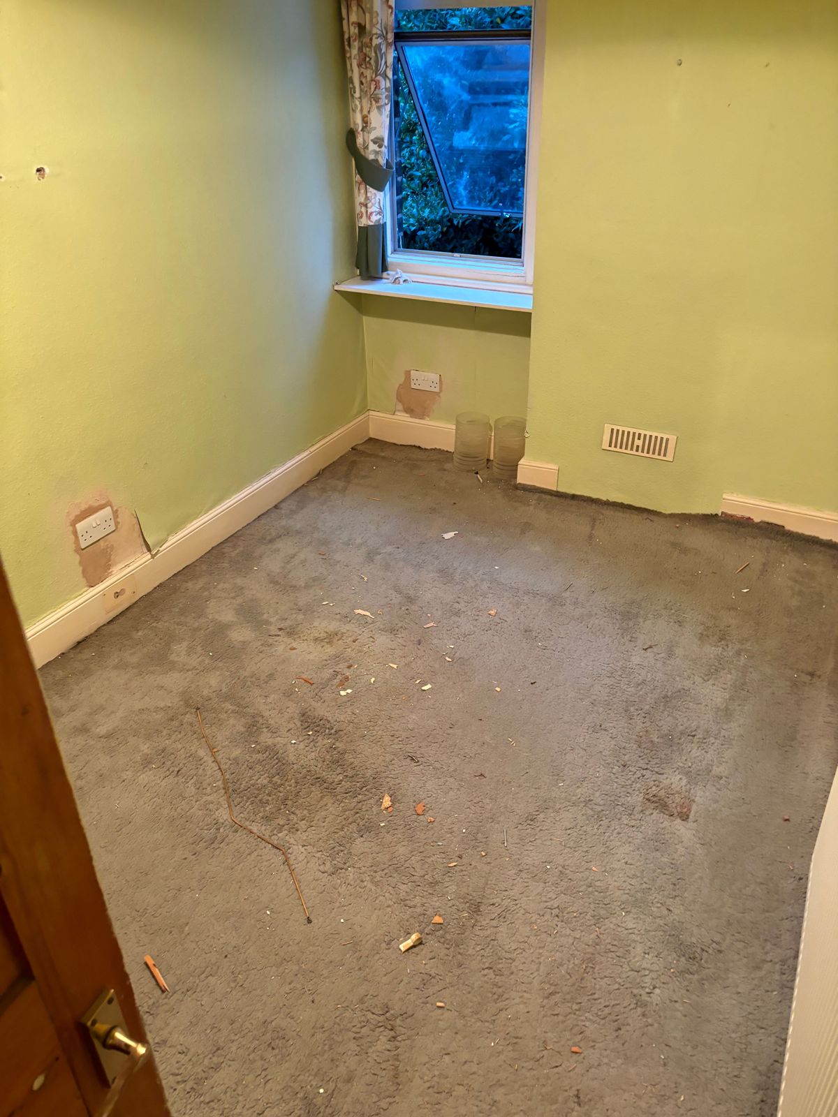 An empty room after the furniture and rubbish had been taken.